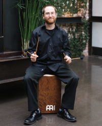 Adam Forman sitting on a cajon